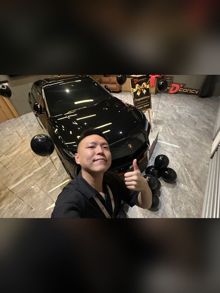 Eden with a black supercar at handover